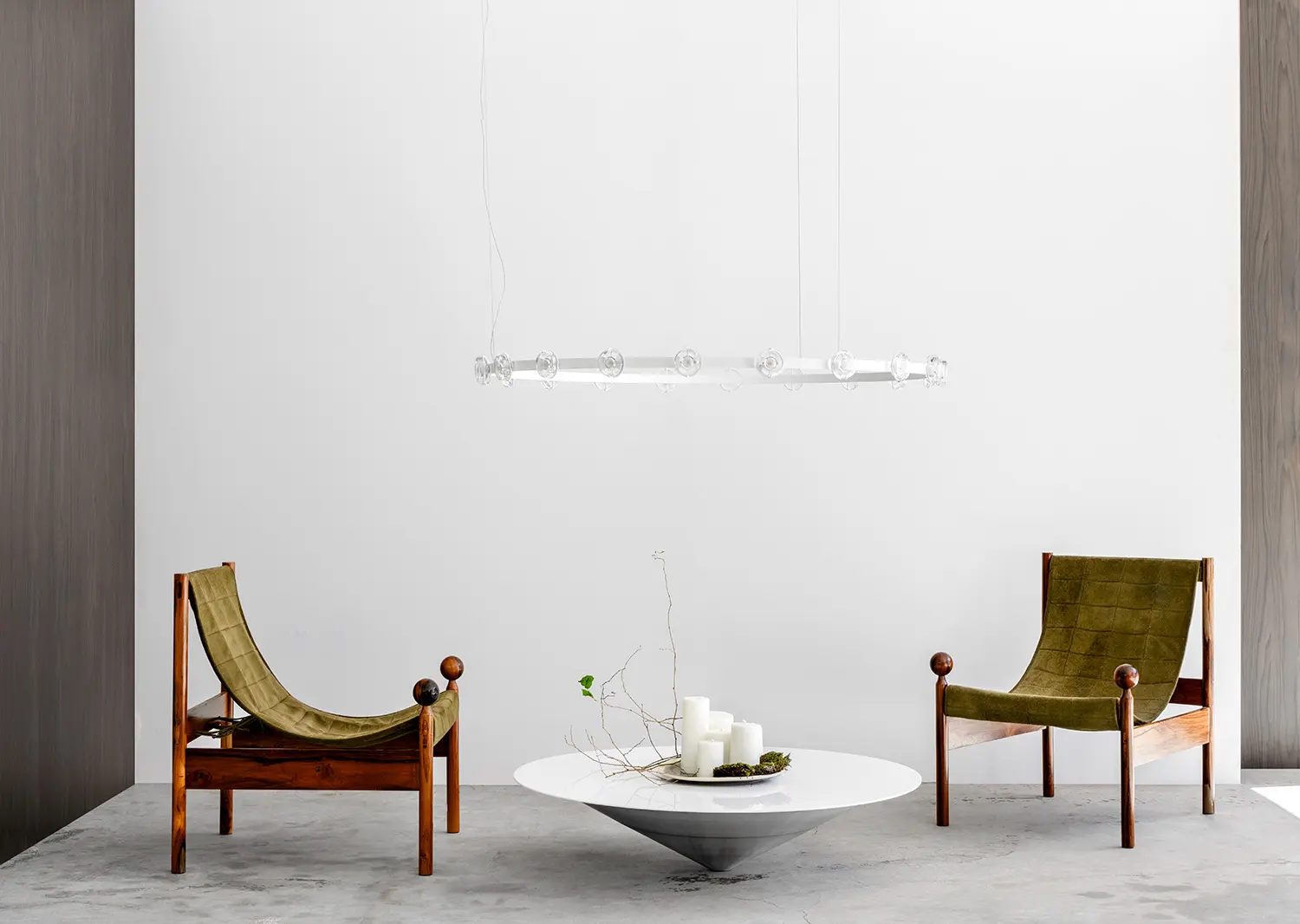 Ambiente com luminária suspensa tubular e cadeiras em couro verde — produção WJ Luminárias por Studio Guilherme Garcia