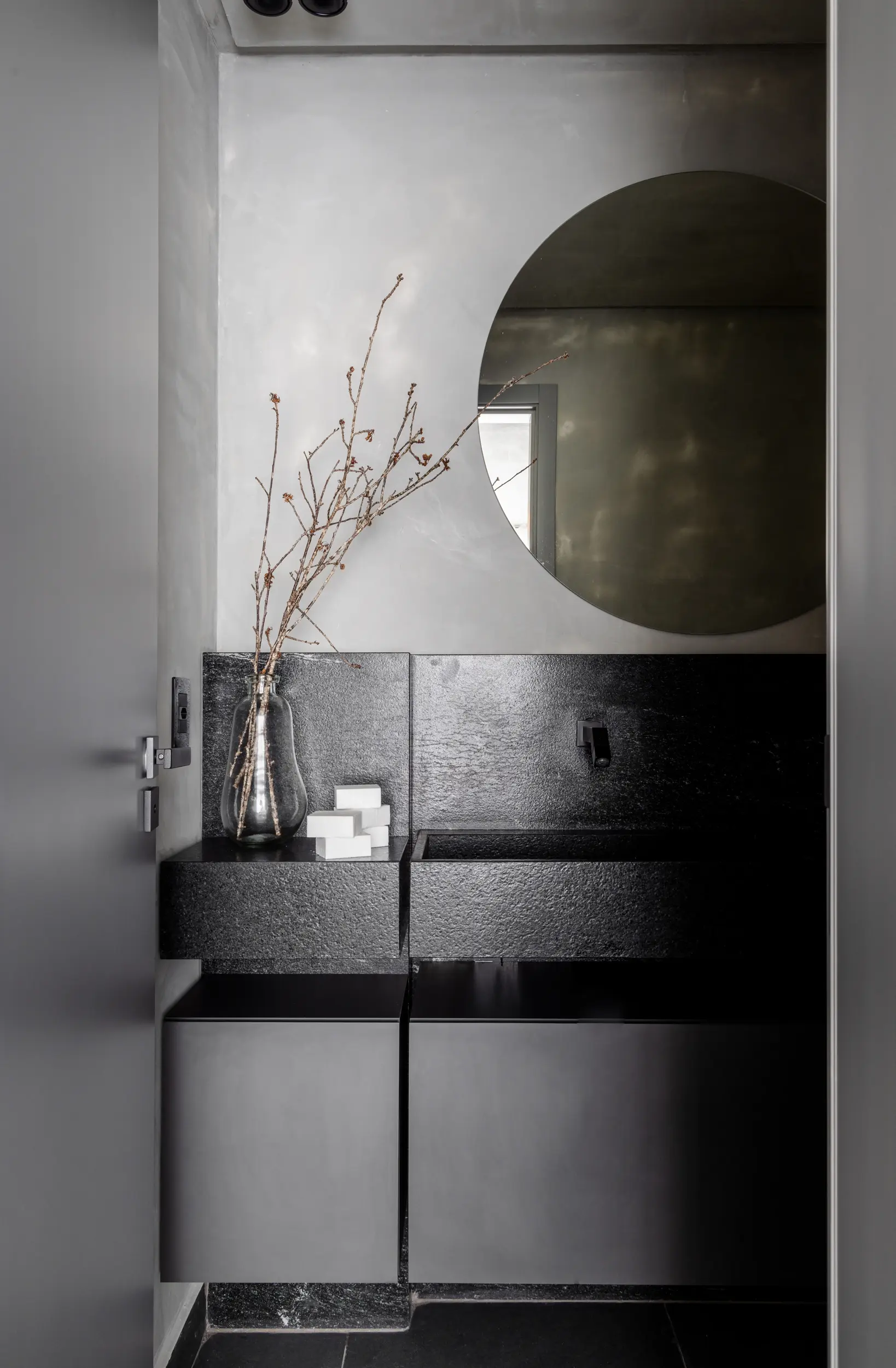 Detalhe decorativo com galho seco e espelho orgânico no Apto Prisma, por Studio Guilherme Garcia.