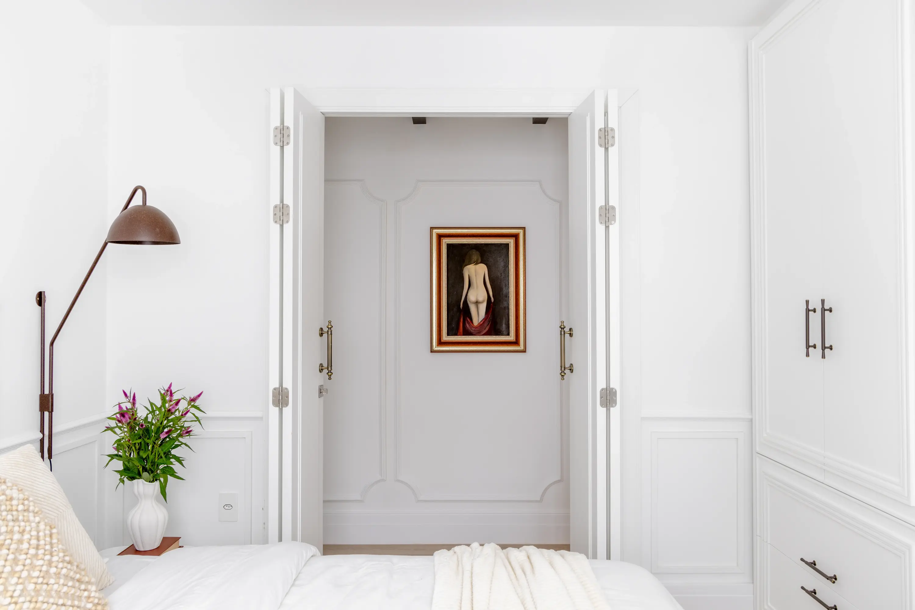 Corredor com boiseries e quadro clássico centralizado, projeto Lab Paris por Studio Guilherme Garcia.