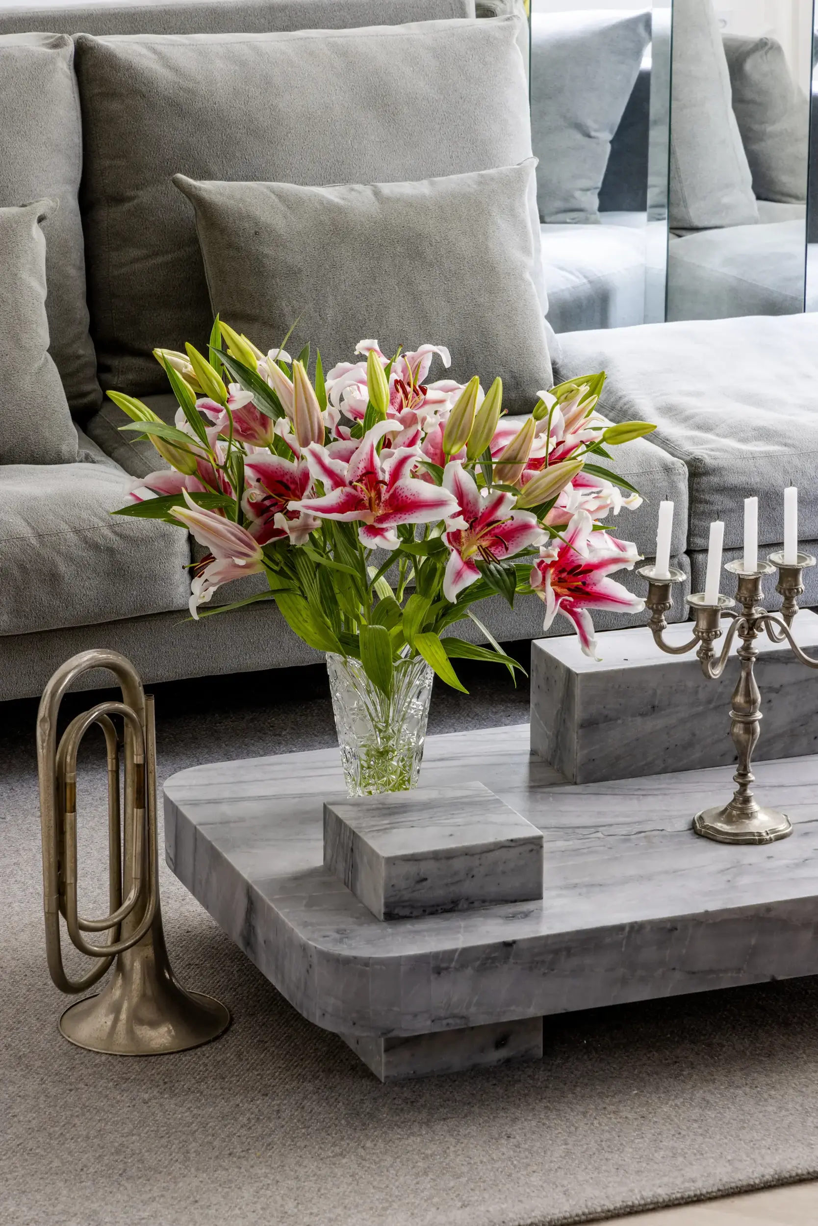 Sala com sofá verde, mesa de centro de mármore e flores coloridas, projeto Lab Paris por Studio Guilherme Garcia.