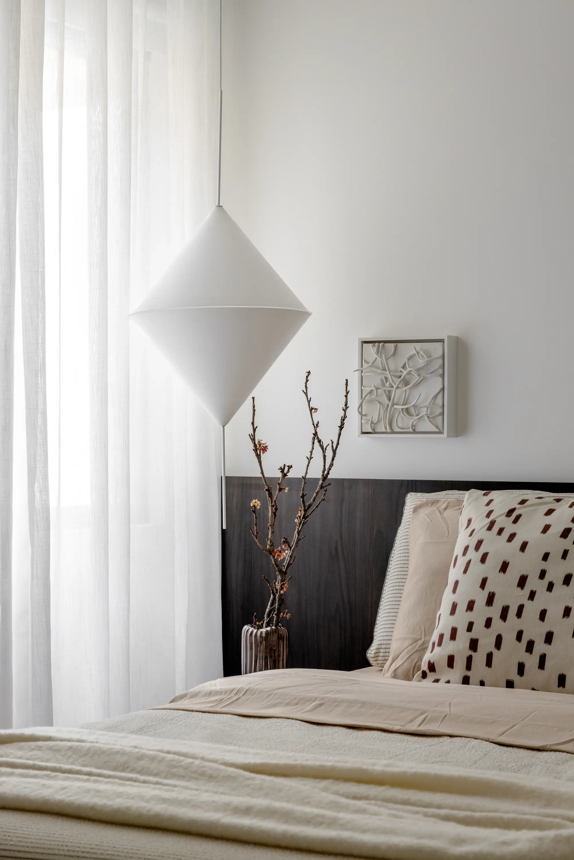 Quarto com cama baixa e luminária escultural branca pendente, projeto Lab 06 por Studio Guilherme Garcia.