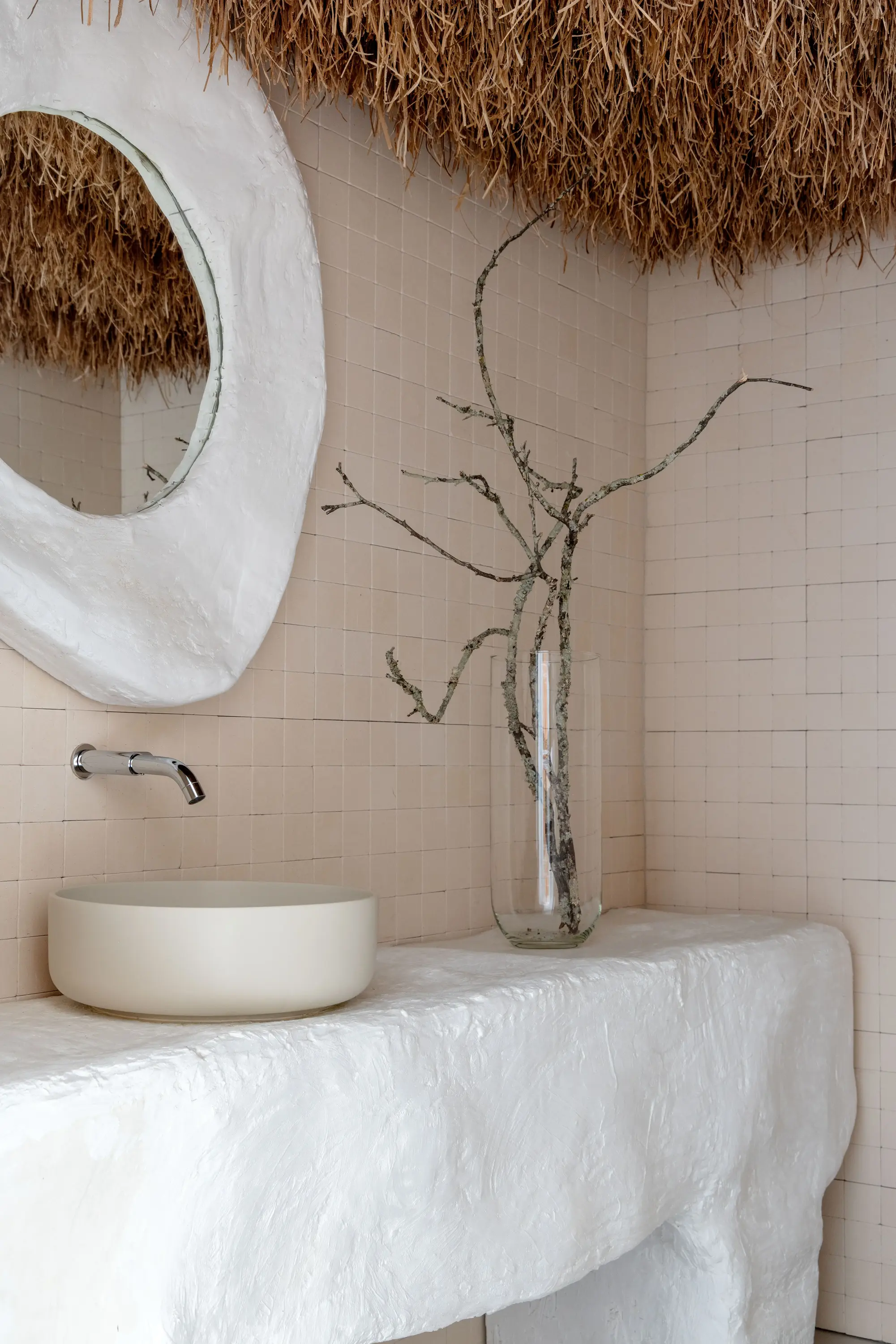 Detalhe decorativo com espelho circular e galhos secos no projeto Tempo Casa por Studio Guilherme Garcia