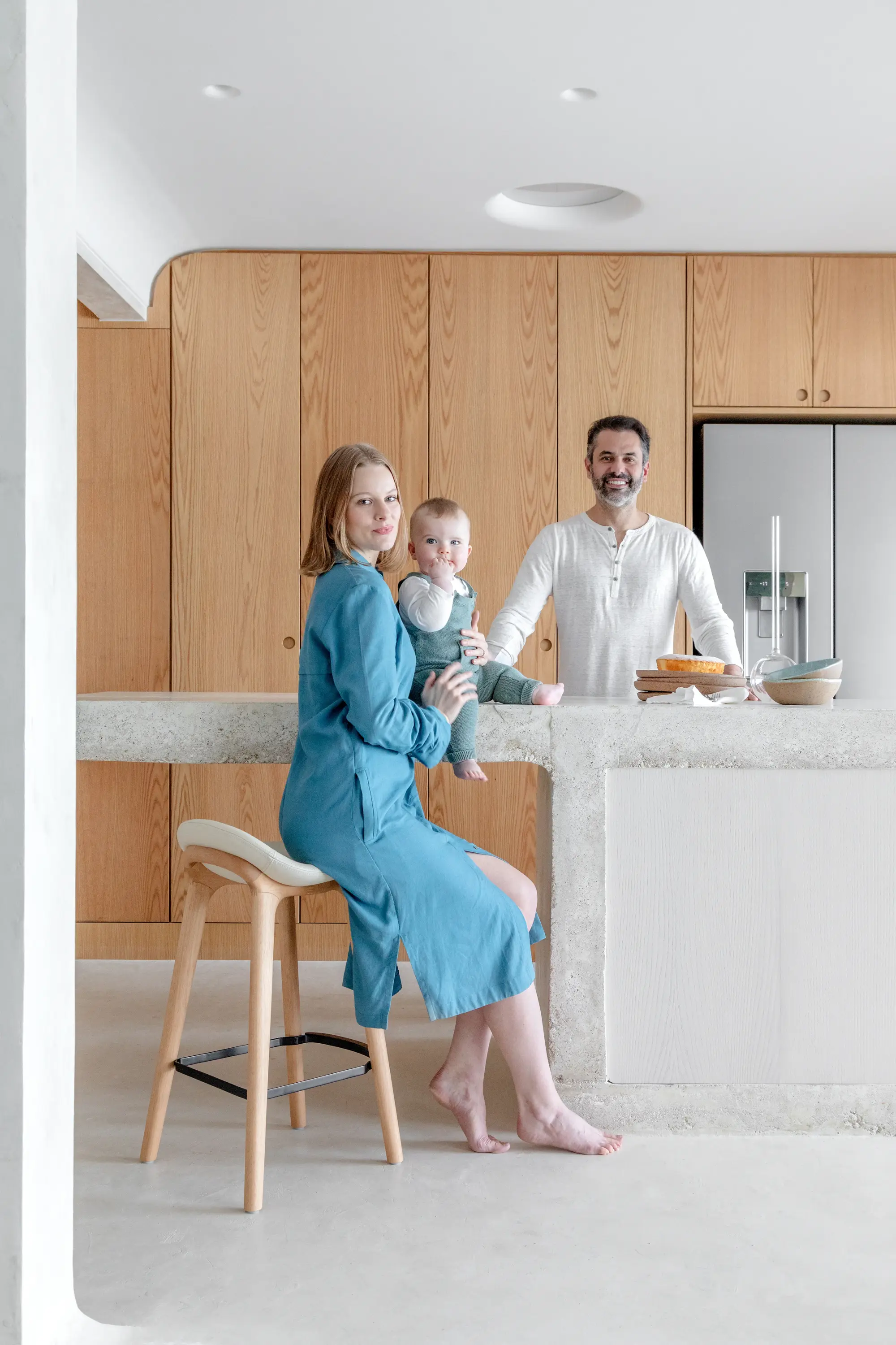 Família reunida na cozinha do Apto Puro, com estética minimalista e natural desenvolvida pelo Studio Guilherme Garcia.