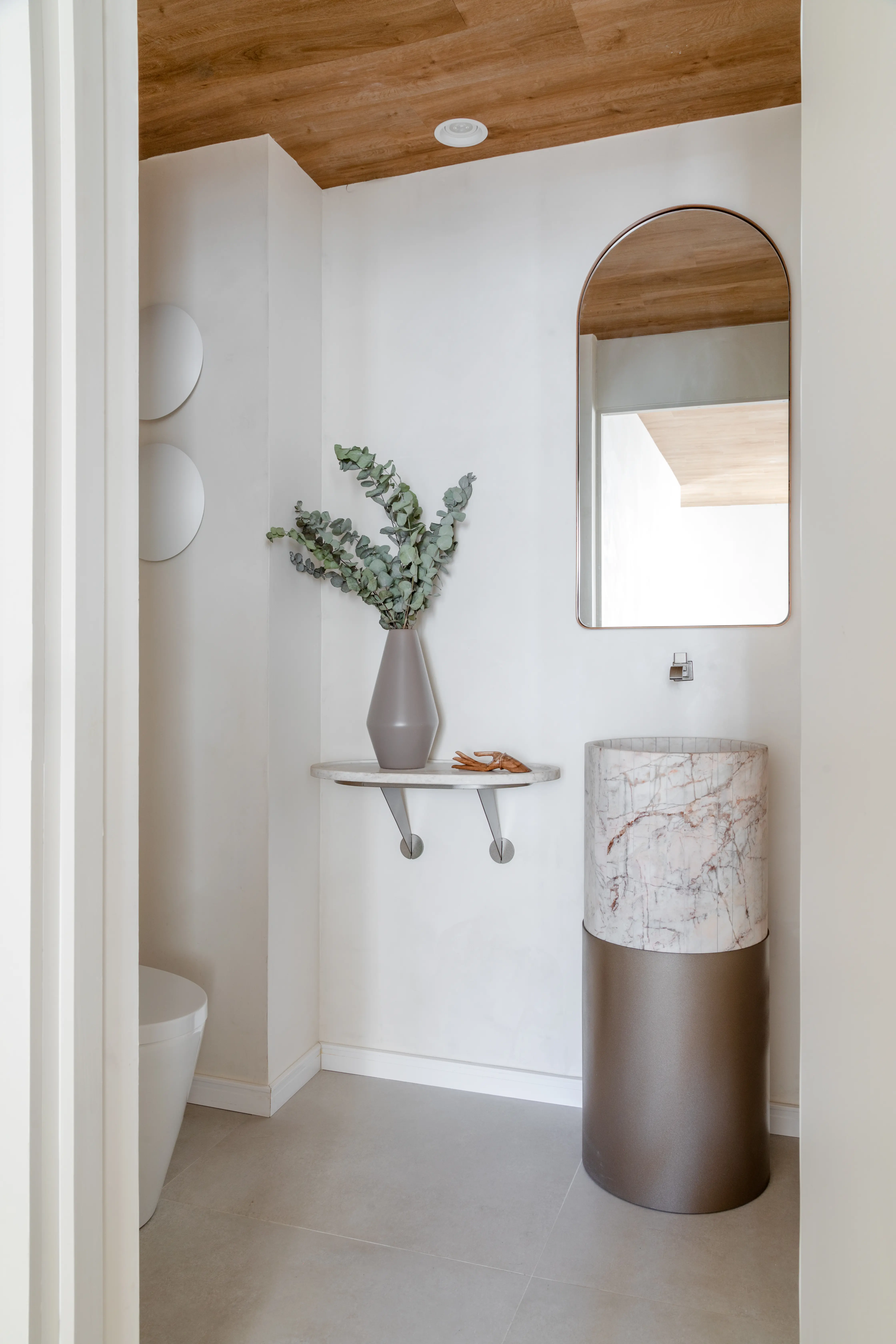 Banheiro com espelho orgânico e bancada em pedra — Clínica Baumgarten