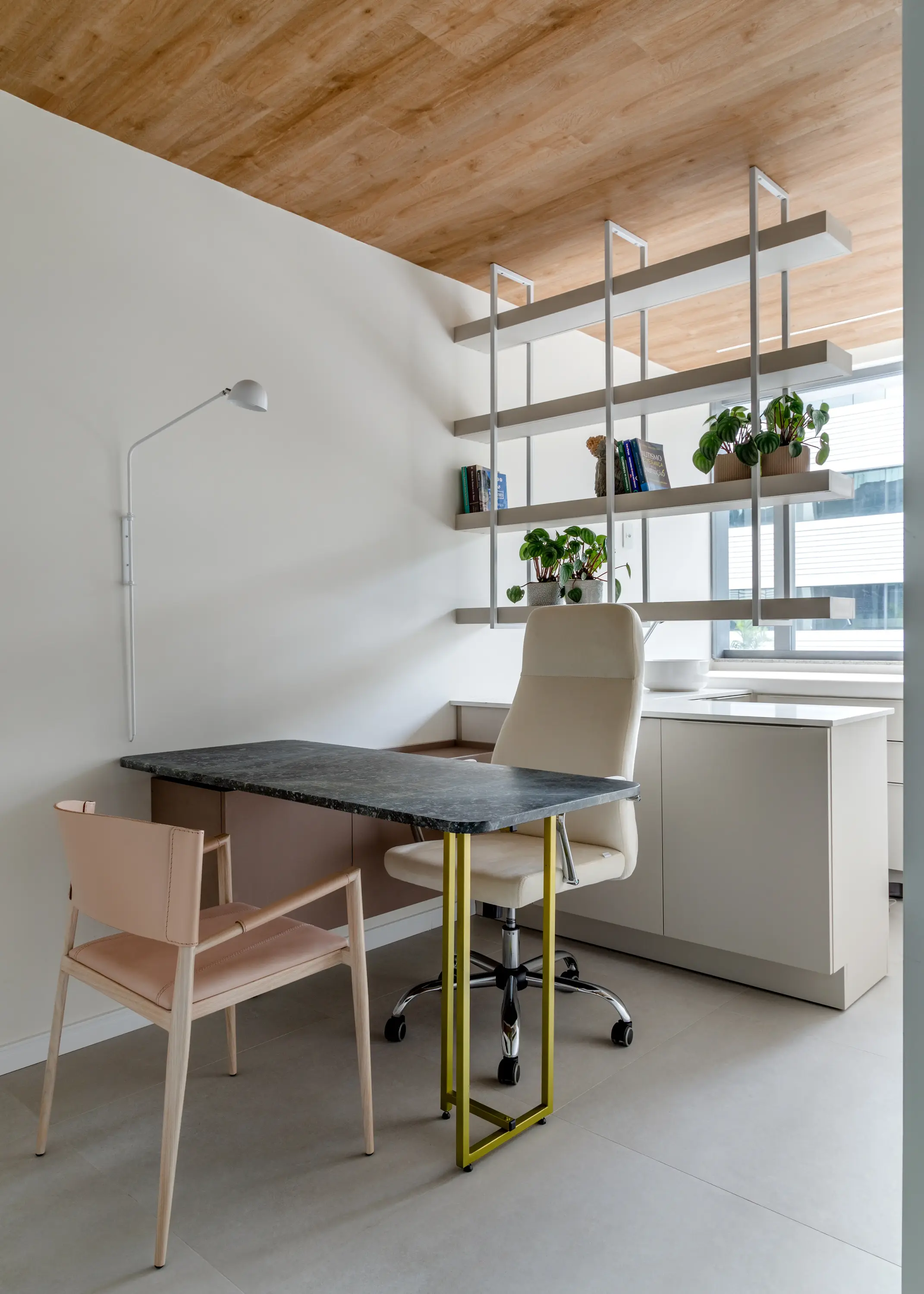 Consultório com mesa branca, estante metálica e plantas — arquitetura para bem-estar por Studio Guilherme Garcia