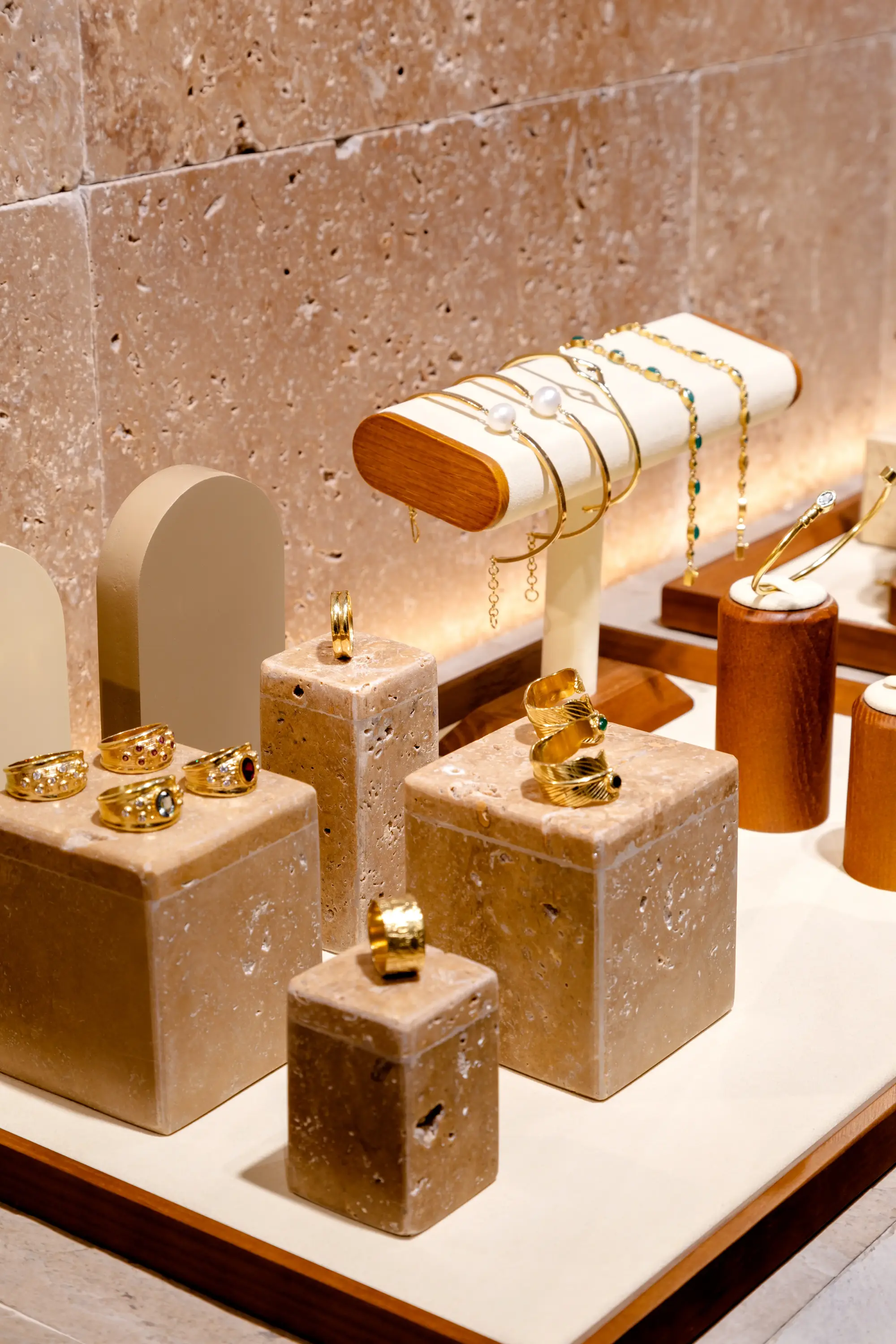 Joias expostas em base de pedra com iluminação pontual no projeto da Moretto Joalheria por Studio Guilherme Garcia