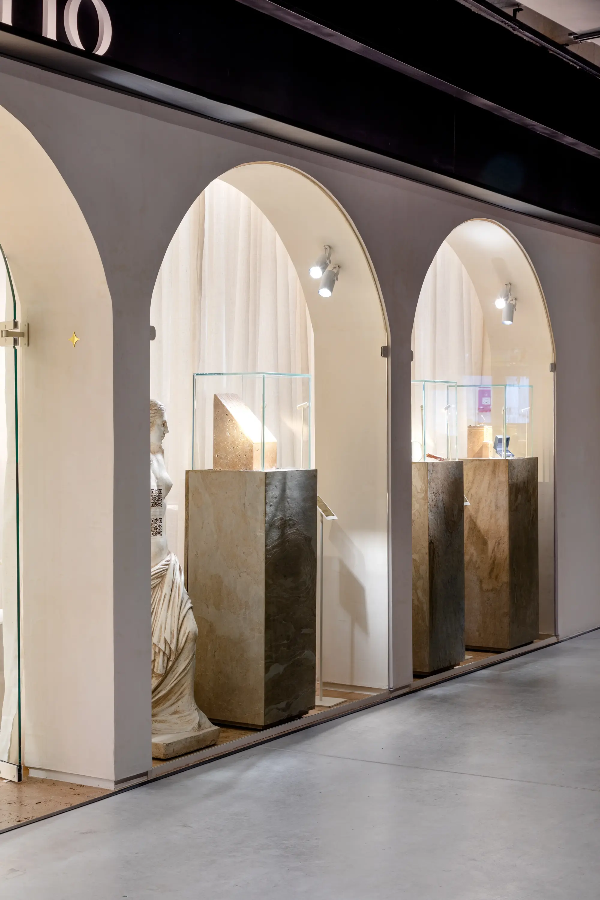 Vista lateral da fachada com arcos iluminados no projeto Moretto Joalheria por Studio Guilherme Garcia