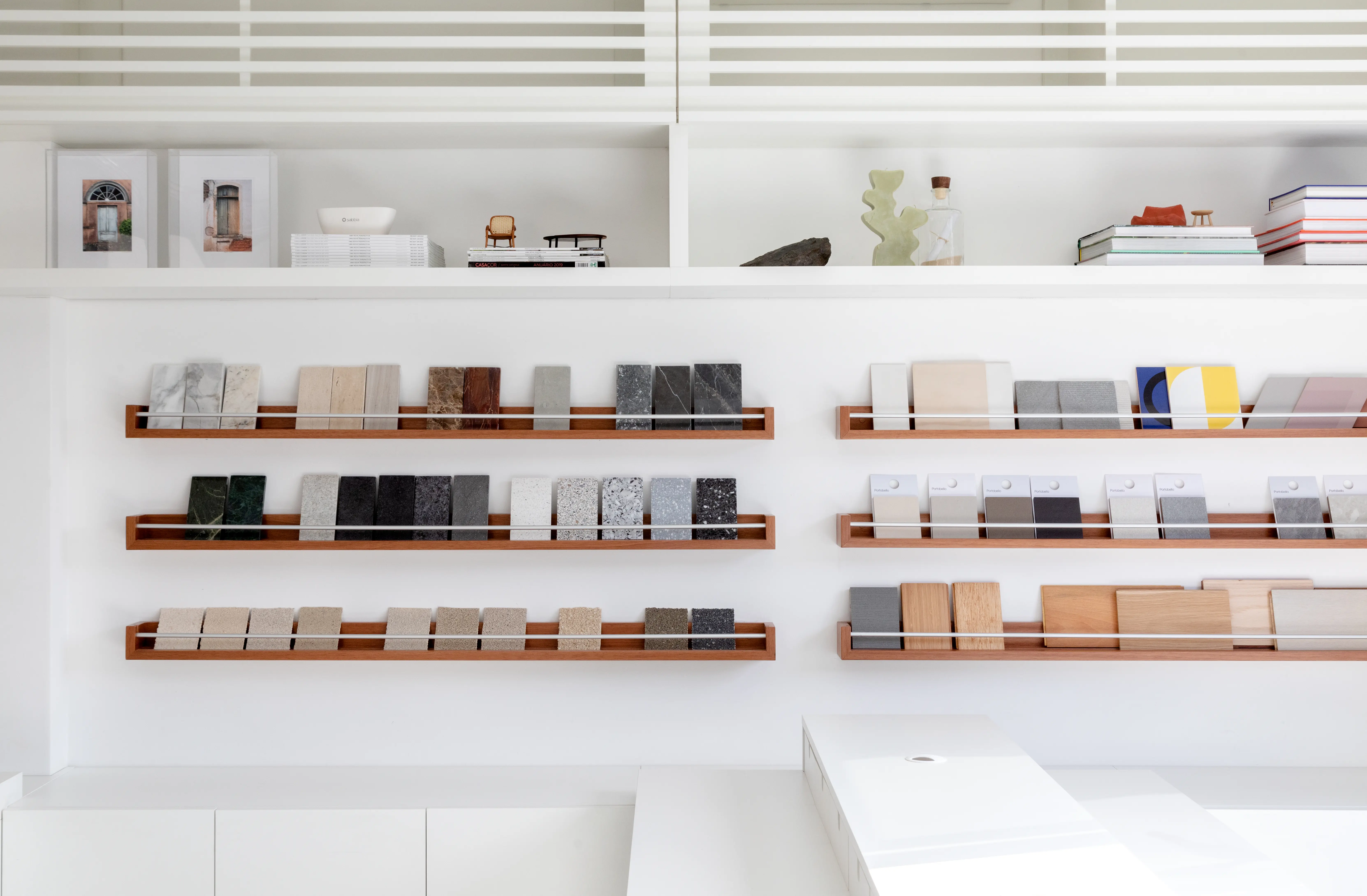 Estante modular com livros e materiais no Escritório SGG — organização e estética por Studio Guilherme Garcia