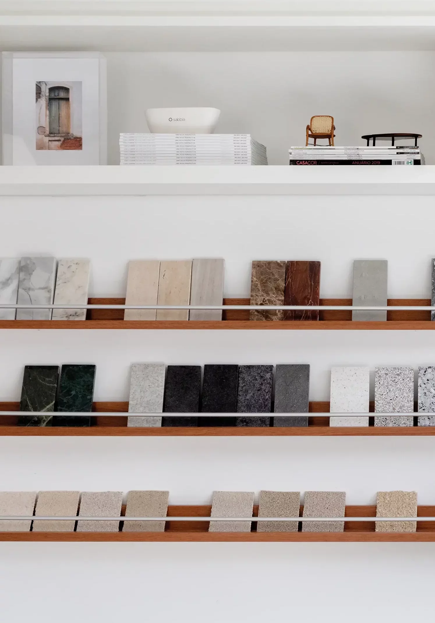 Estante com amostras de texturas e materiais no Studio Guilherme Garcia