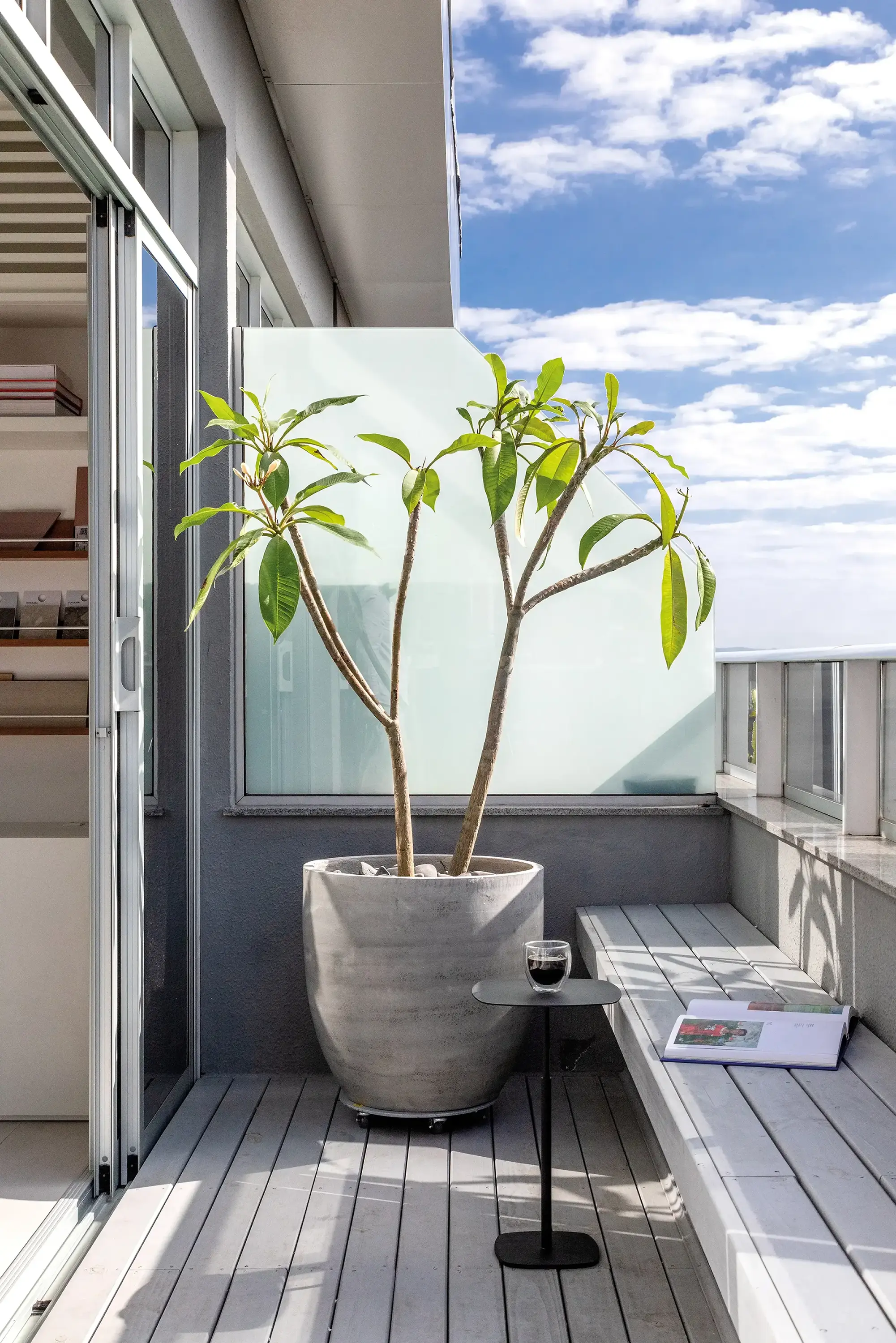 Varanda com vaso de planta e vista externa em projeto do Studio Guilherme Garcia