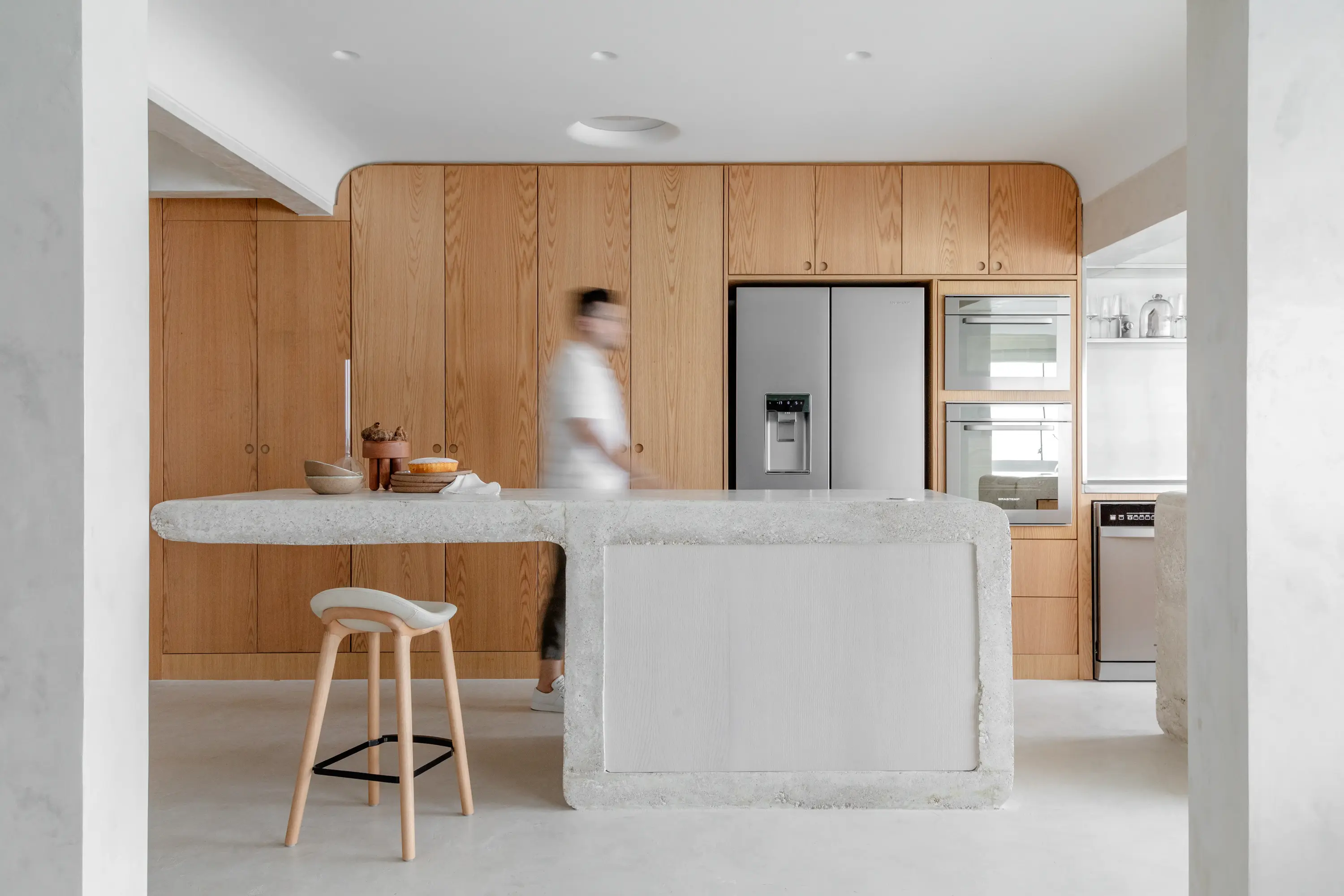 Cozinha minimalista do Apto Puro com bancada de madeira e cadeira de design moderno, projeto do Studio Guilherme Garcia.