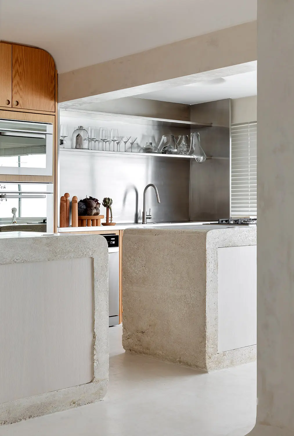 Cozinha do Apto Puro com bancada em concreto aparente e acabamento em inox, projeto sofisticado do Studio Guilherme Garcia.